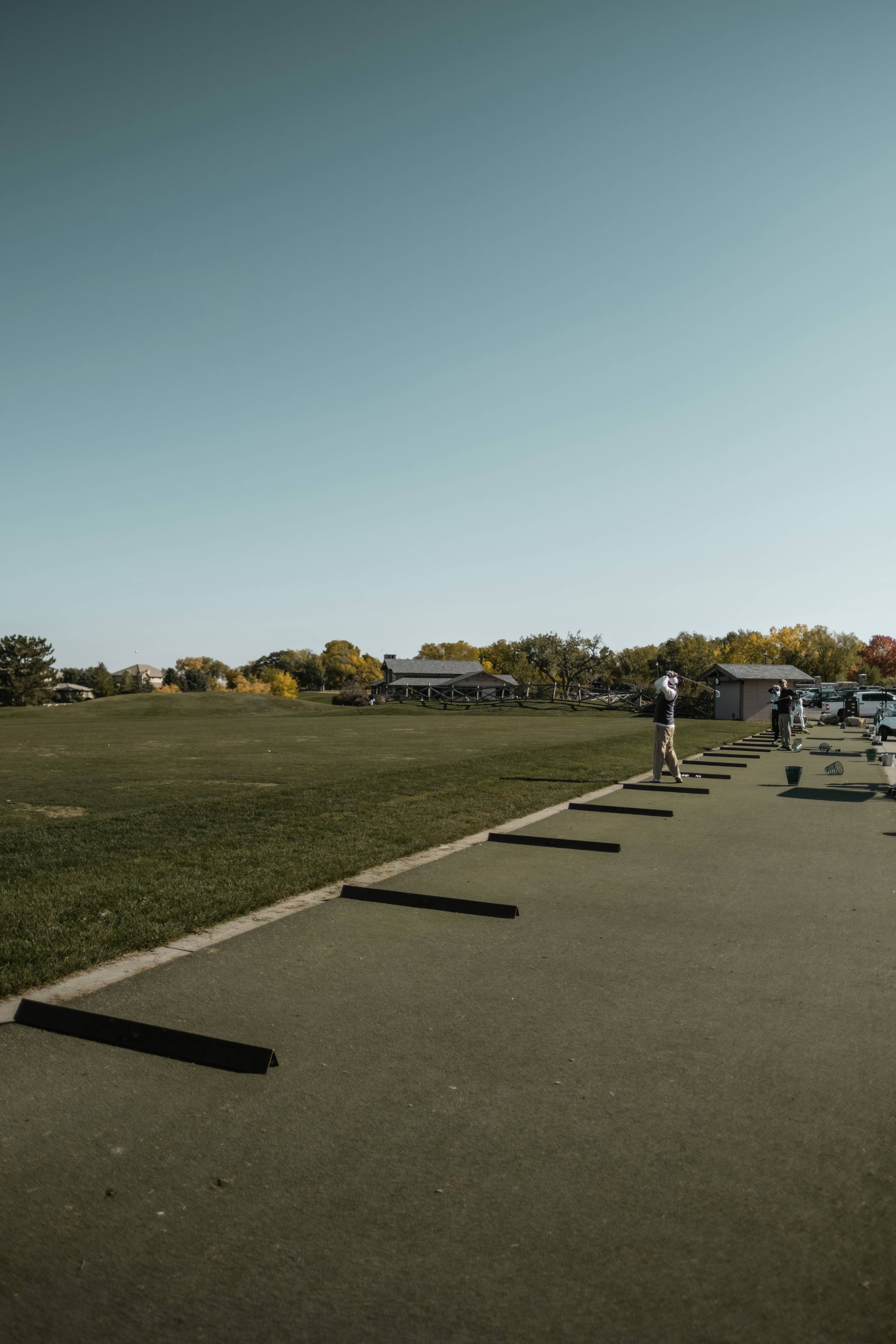 Golfer practicing alone at a driving range, working on their swing and ball striking.