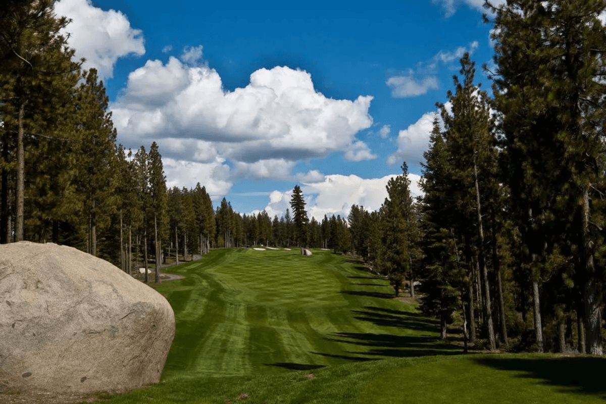 Coyote Moon Golf Course fairway framed by pine trees and boulders in Truckee, California