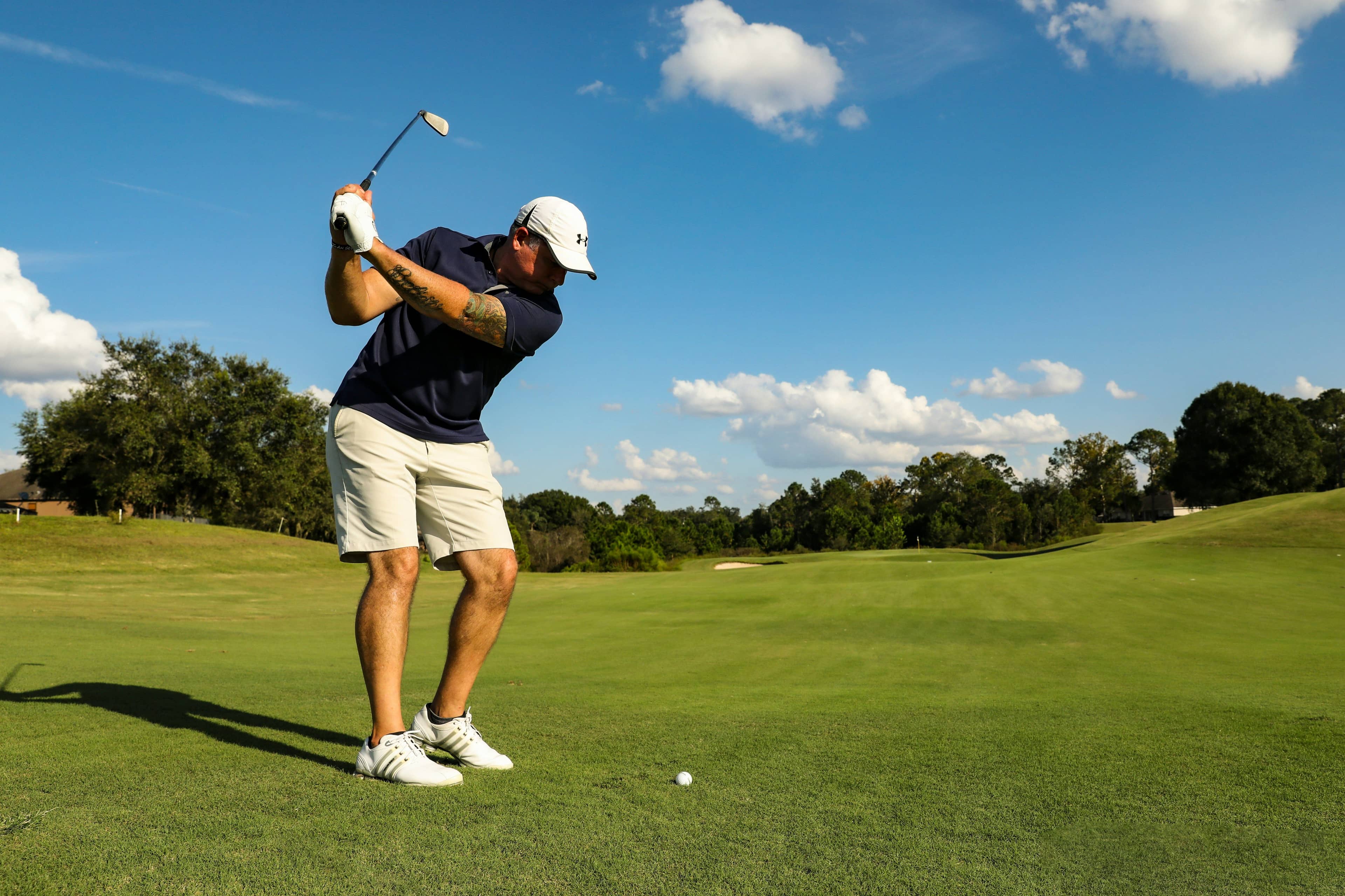 Golfer hits an iron shot from the fairway during a round of golf.