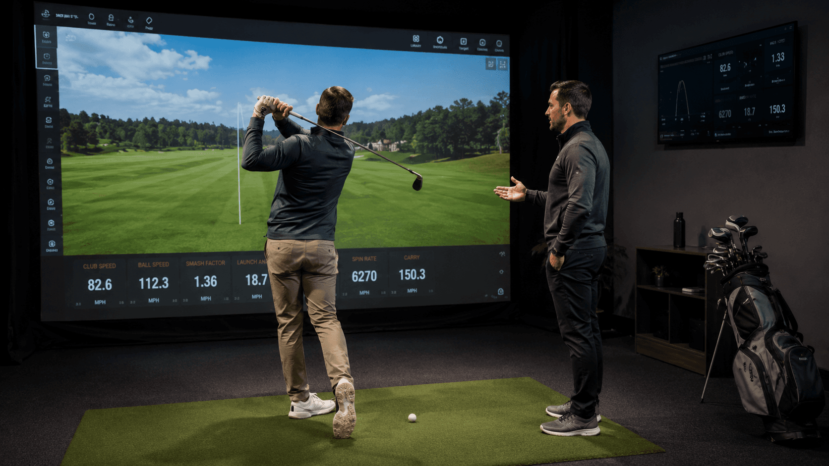 Golf coach watches a beginner-level golfer hit a shot during an indoor simulator lesson, with launch monitor data and a virtual course displayed on a large screen.